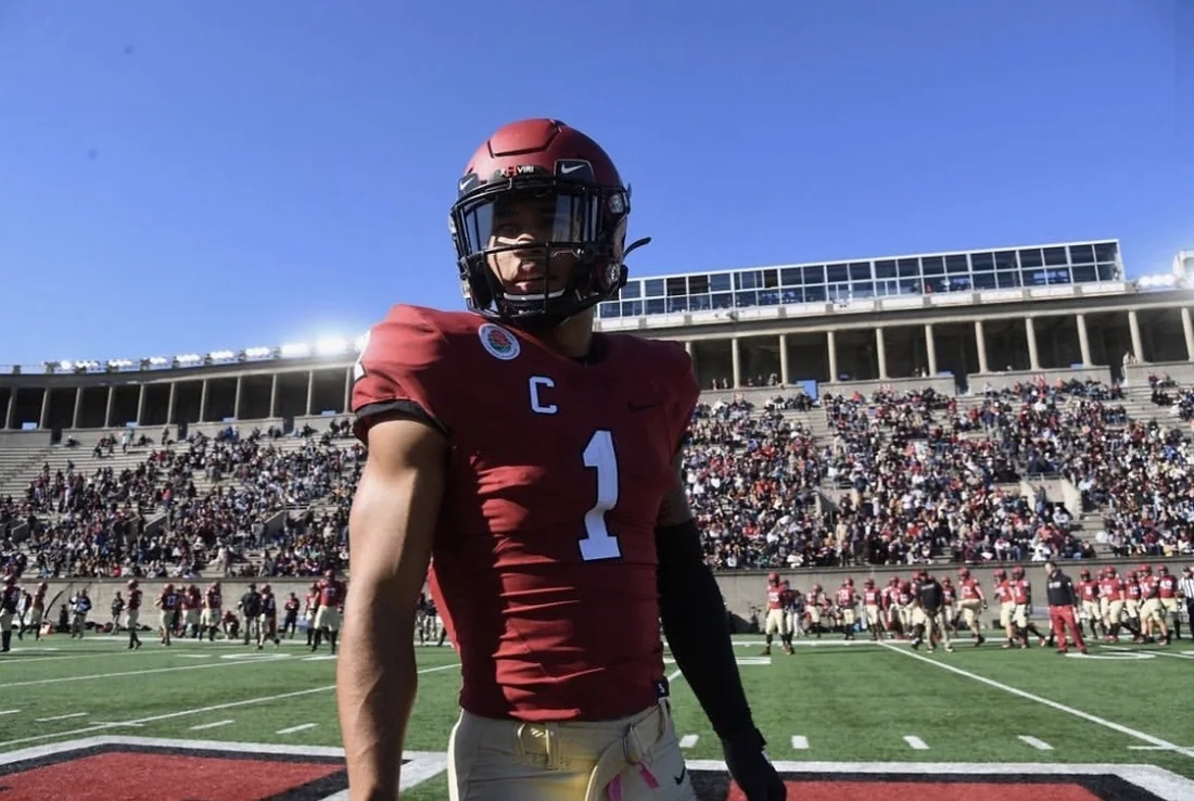 Wes on the field at Harvard, captain's patch on his jersey